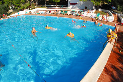 Rilassarsi in piscina sotto il caldo e cocente sole estivo